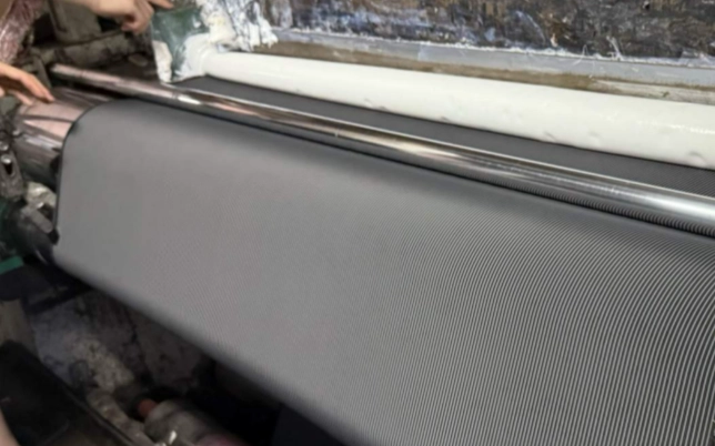 Woven fabric passing through a coating and finishing process