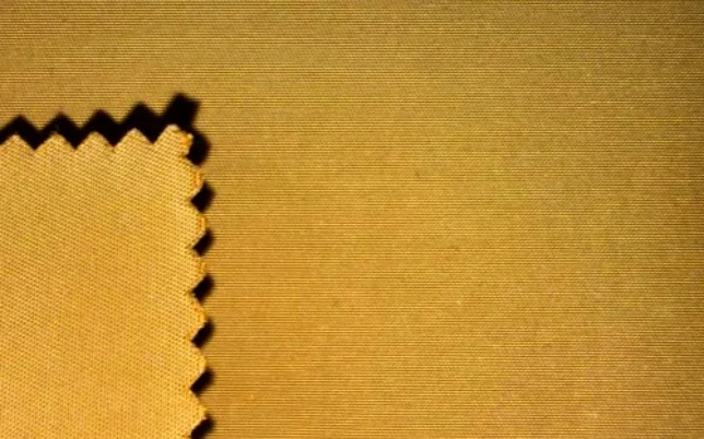 Close-up of yellow woven fabric with a pinked-edge swatch.