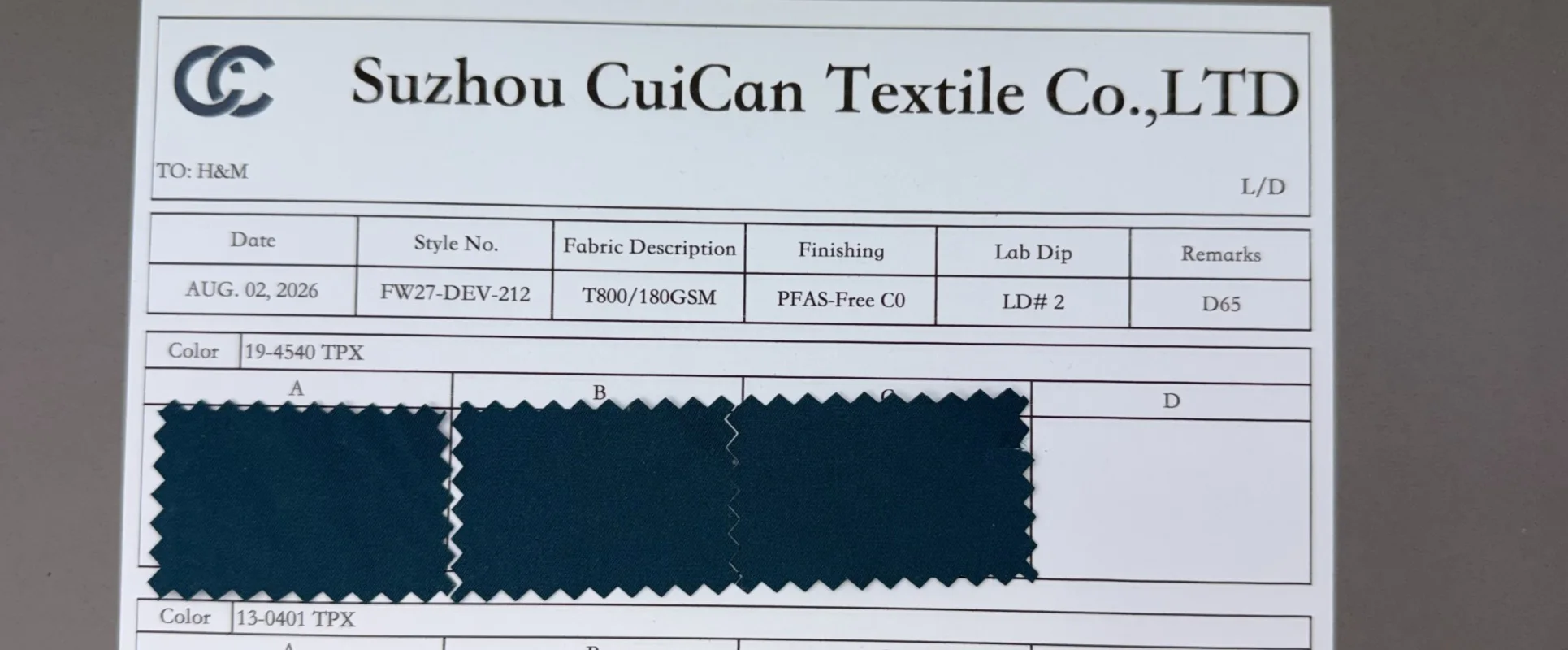 Outdoor woven fabric samples and a finished shell jacket undergoing laboratory performance testing